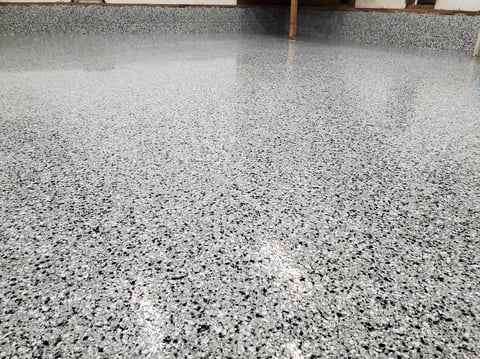 Polished concrete floor with gray and white speckled aggregate finish in an interior space